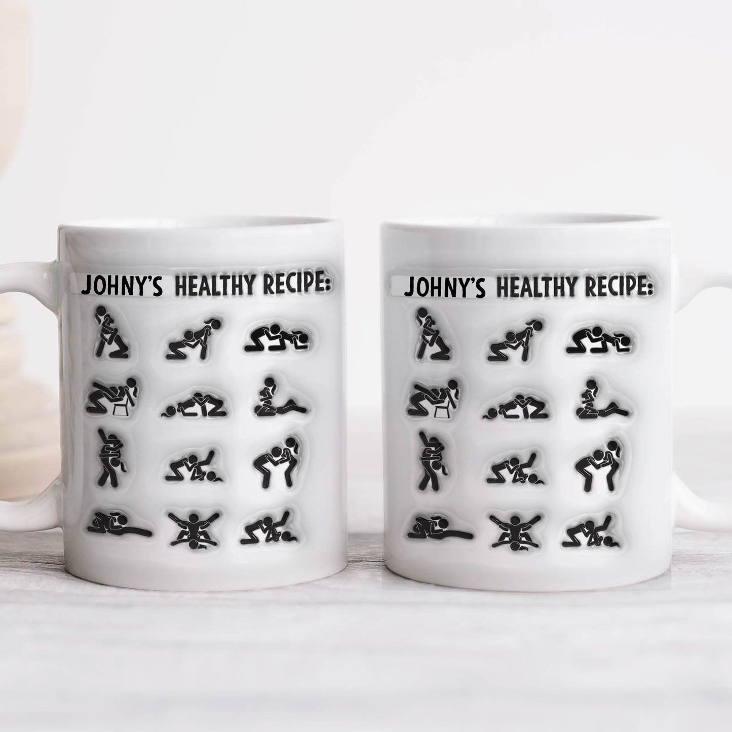 Two white ceramic mugs printed with Johnys Healthy Recipe pictograms of couple poses, unique couples gift mug