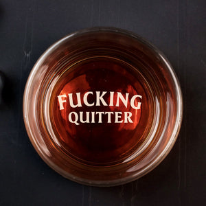 Top view of 365Gifty Personalized Whiskey Glass with amber whiskey and bold engraved wording FUCKING QUITTER