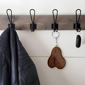 Acrylic shaking keychain for fathers featuring a humorous design, hanging on a wall hook next to a leather jacket