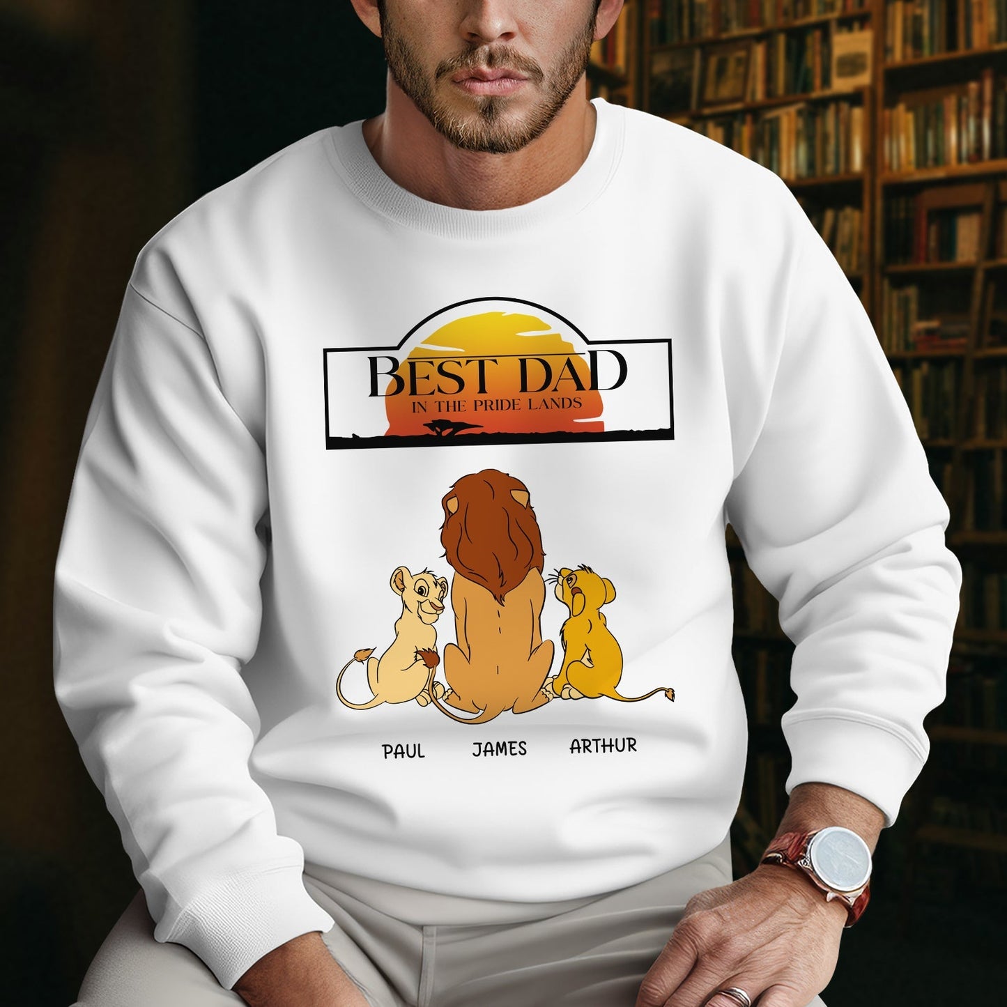 White sweatshirt with cartoon lions and sunset graphic featuring Best Dad in the Pride Lands gift text