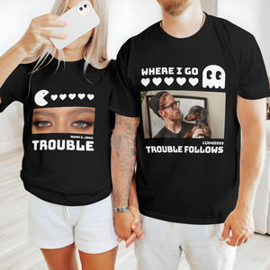 Couple wearing black matching trouble shirts for couples holding hands, featuring playful graphic designs