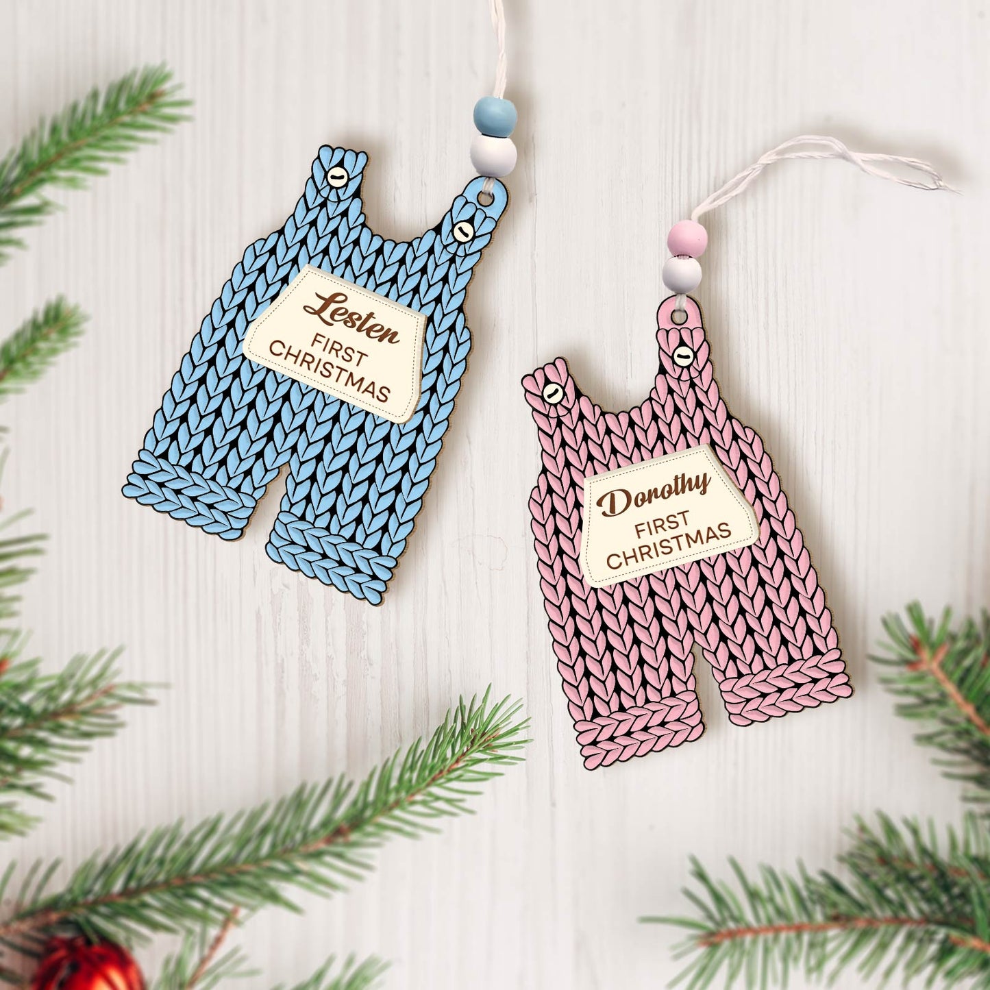 Custom 2-layered Christmas ornament for baby shaped like blue and pink knitted overalls with personalized name tags