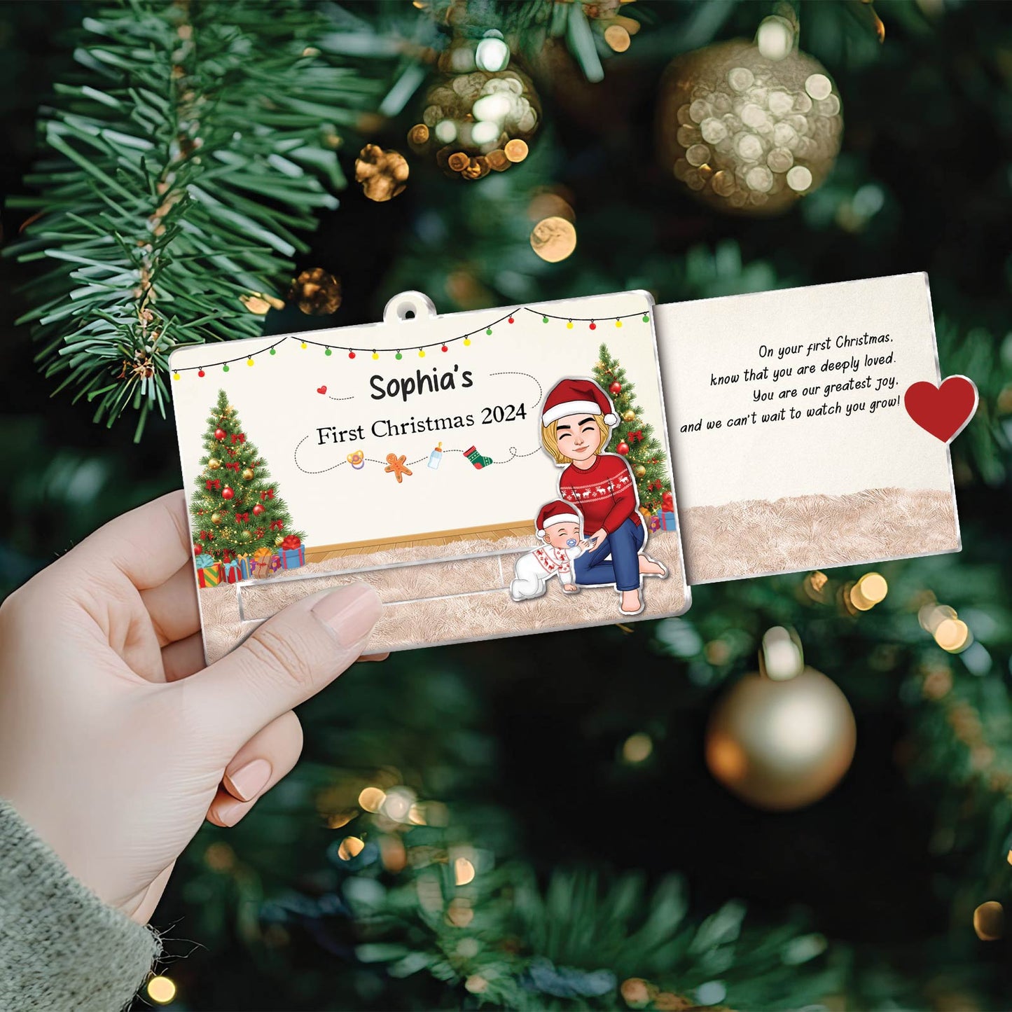 Hand holding custom acrylic Christmas slider card with personalized holiday design and festive Christmas tree background