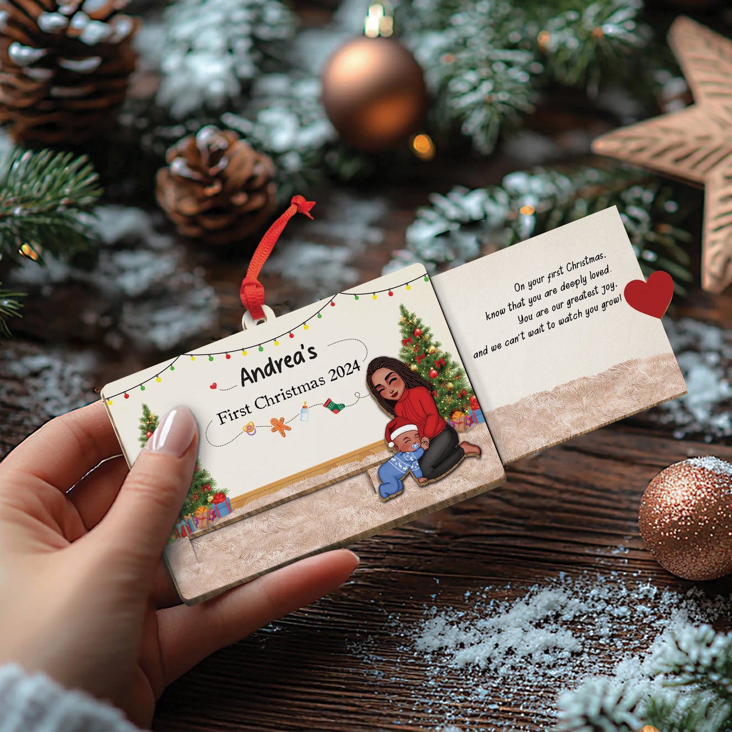 Hand holding custom wooden Christmas slider card with holiday design and personalized text for Andrea's first Christmas 2024
