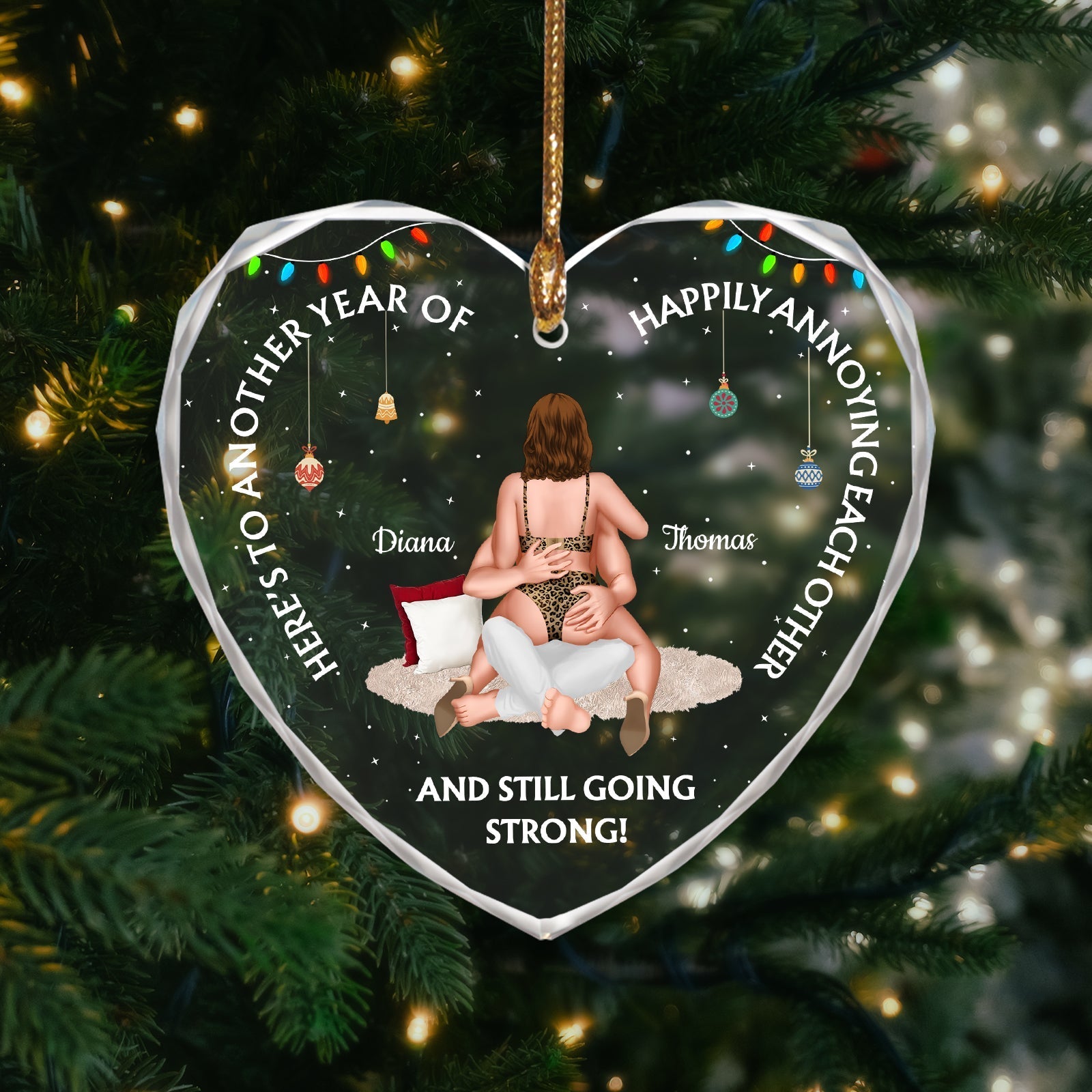 Heart-shaped personalized couple ornament hanging on tree with custom names and holiday lights