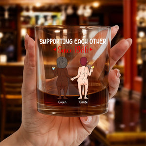 Hand holding Personalized Whiskey Glass with custom cartoon of two nude figures holding hands and names Gwen Dante