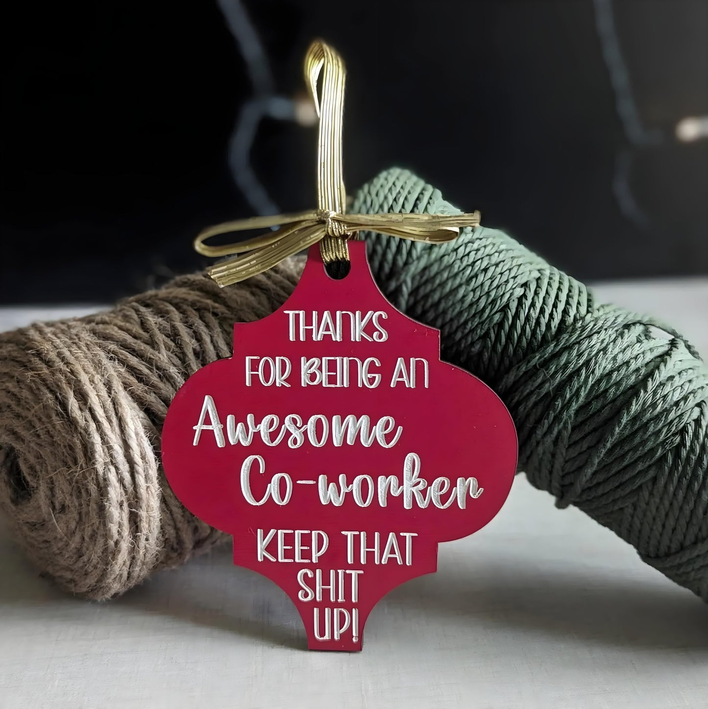 Funny Christmas wooden ornament in red with message for awesome co-worker hanging with gold ribbon