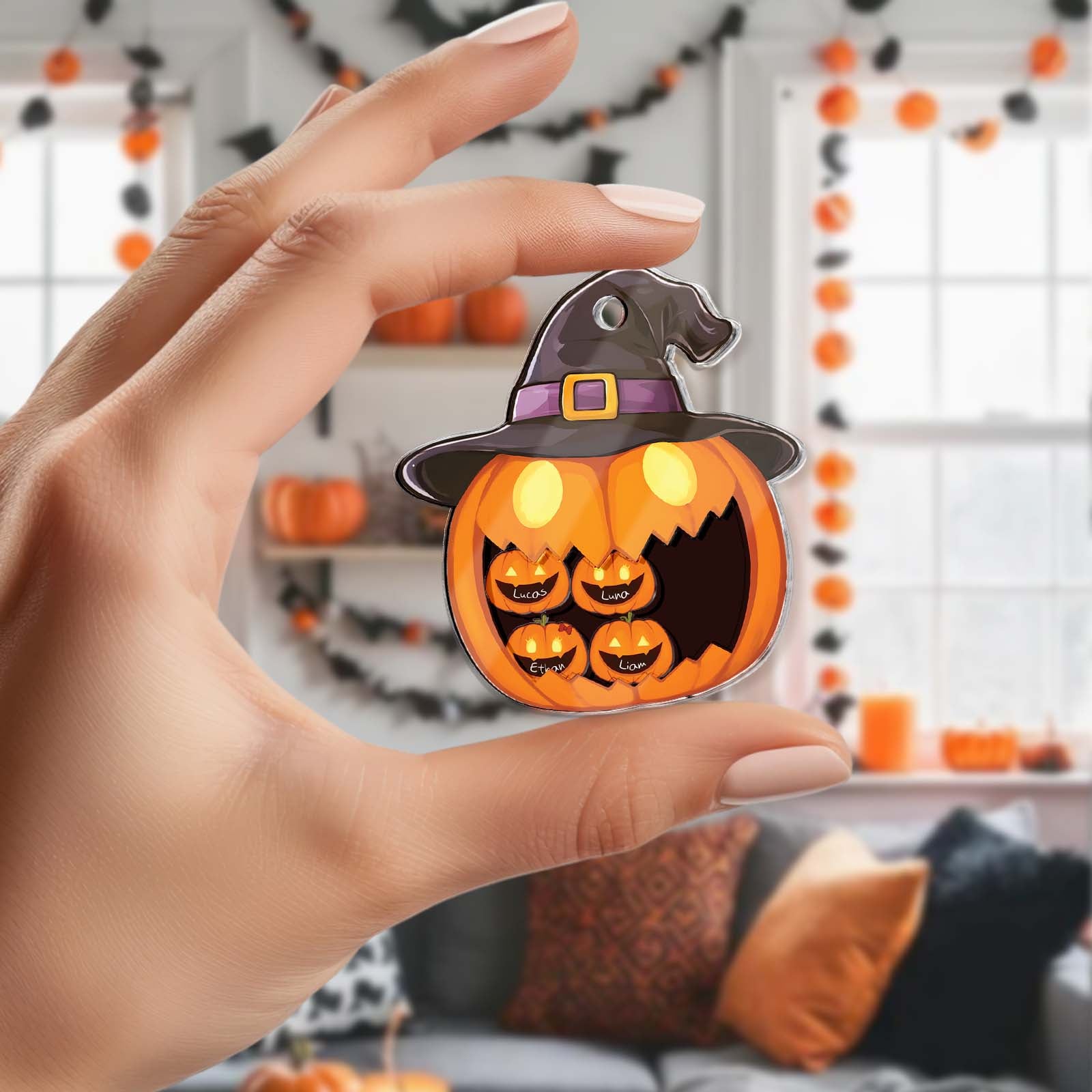 Hand holding Halloween shaking pumpkin keychain with witch hat and glowing eyes in decorated room
