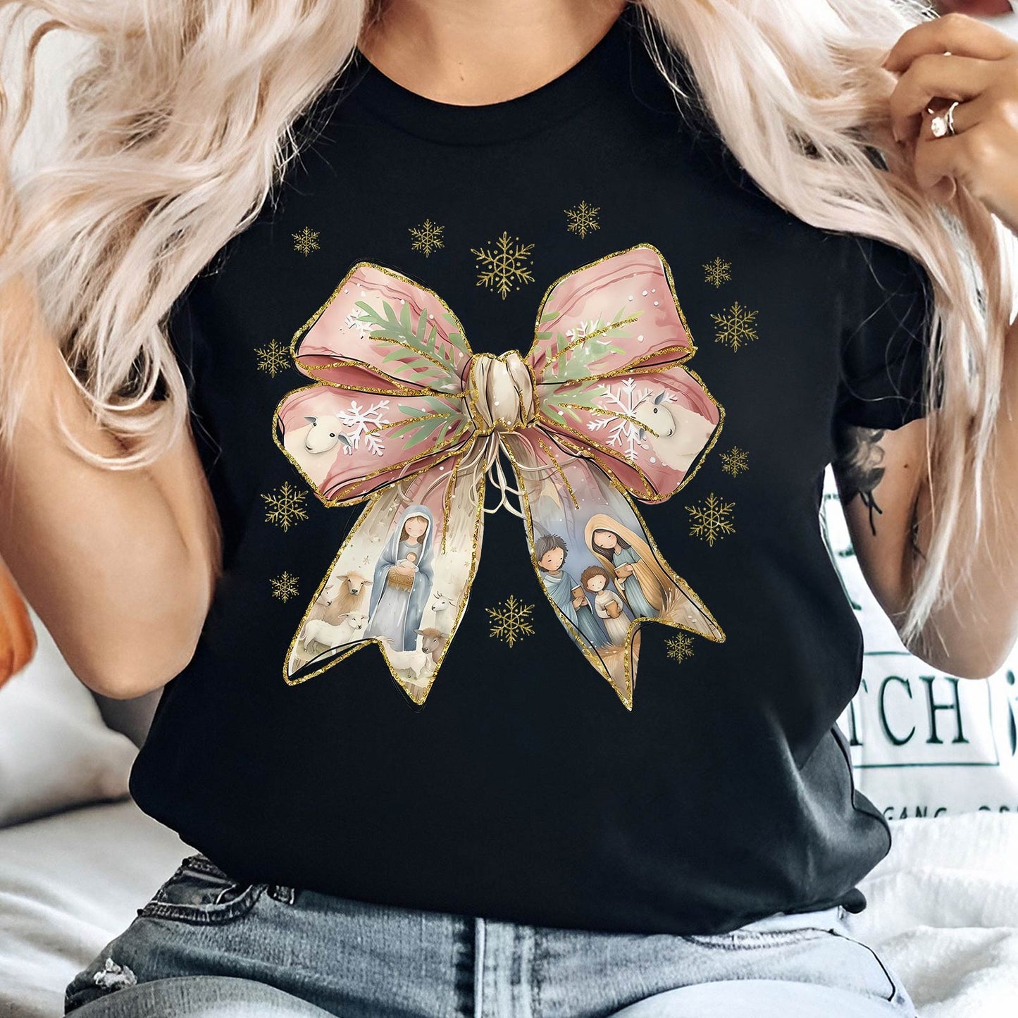 Black Jesus Christmas bow shirt featuring a large pink bow with nativity scene and gold snowflakes