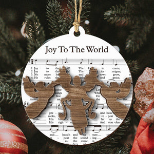 Music sheet nativity ornament featuring Joy To The World sheet music with wooden angel cutouts hanging on Christmas tree