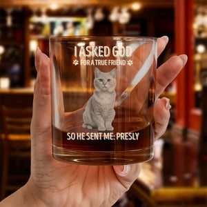Hand holding personalized pet memorial whiskey glass with etched cat portrait and custom memorial text