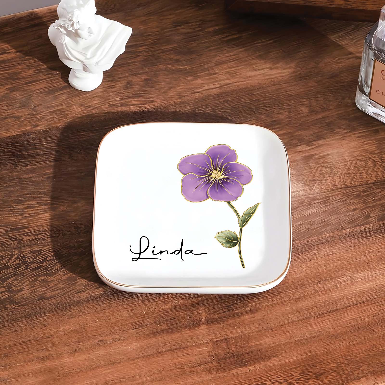 Personalized birth month flower jewelry dish featuring a purple flower and the name Linda