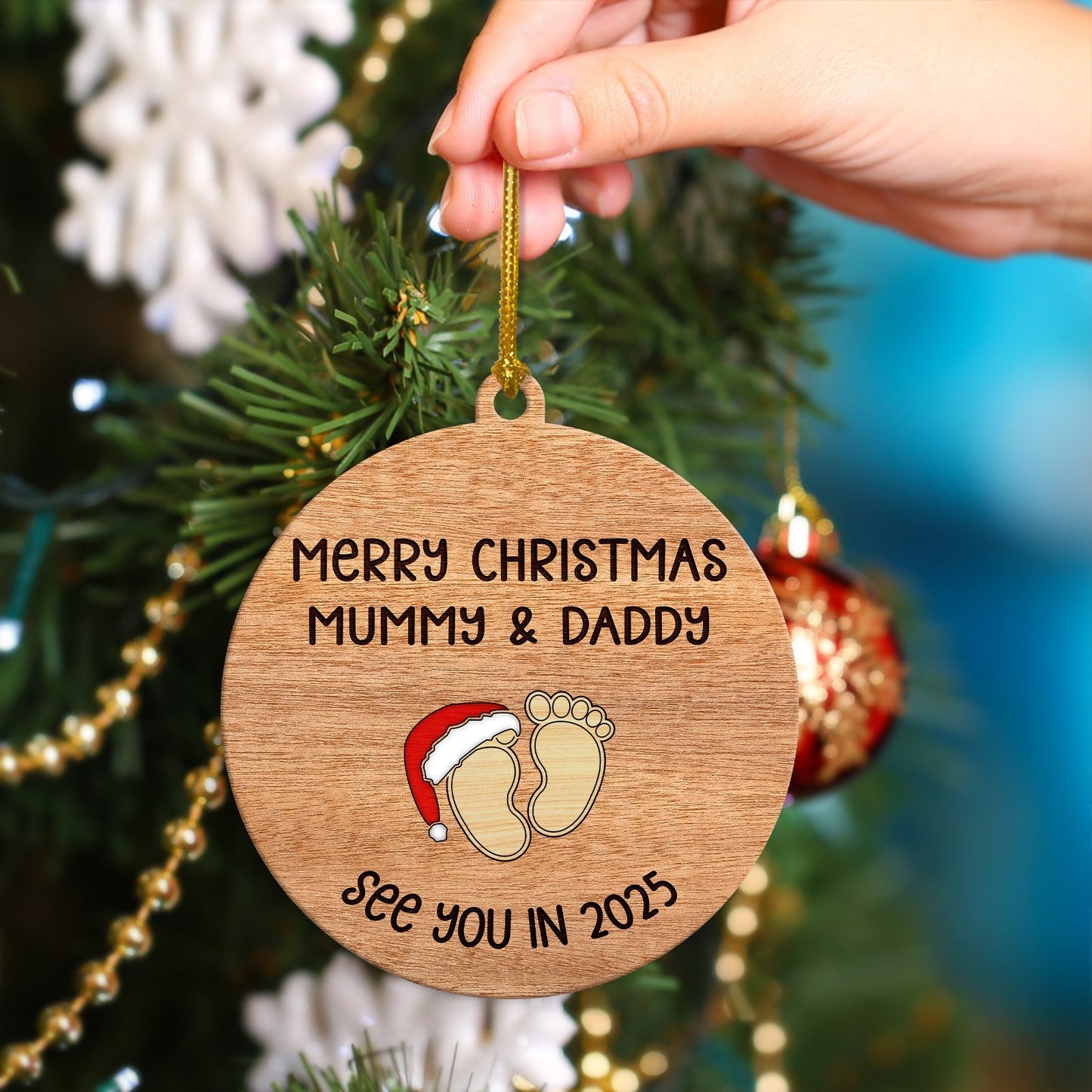 Personalized Christmas ornament for parents with wooden round design and baby footprints hanging on tree