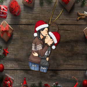 Personalized couple Christmas ornament featuring a kissing couple wearing Santa hats and cozy sweaters with names Jack and Layla