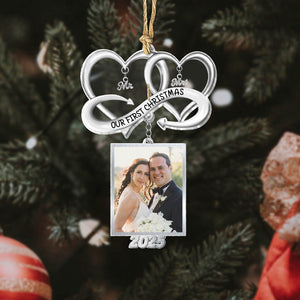 Personalized couple Christmas ornament featuring a photo frame and 'Our First Christmas' design