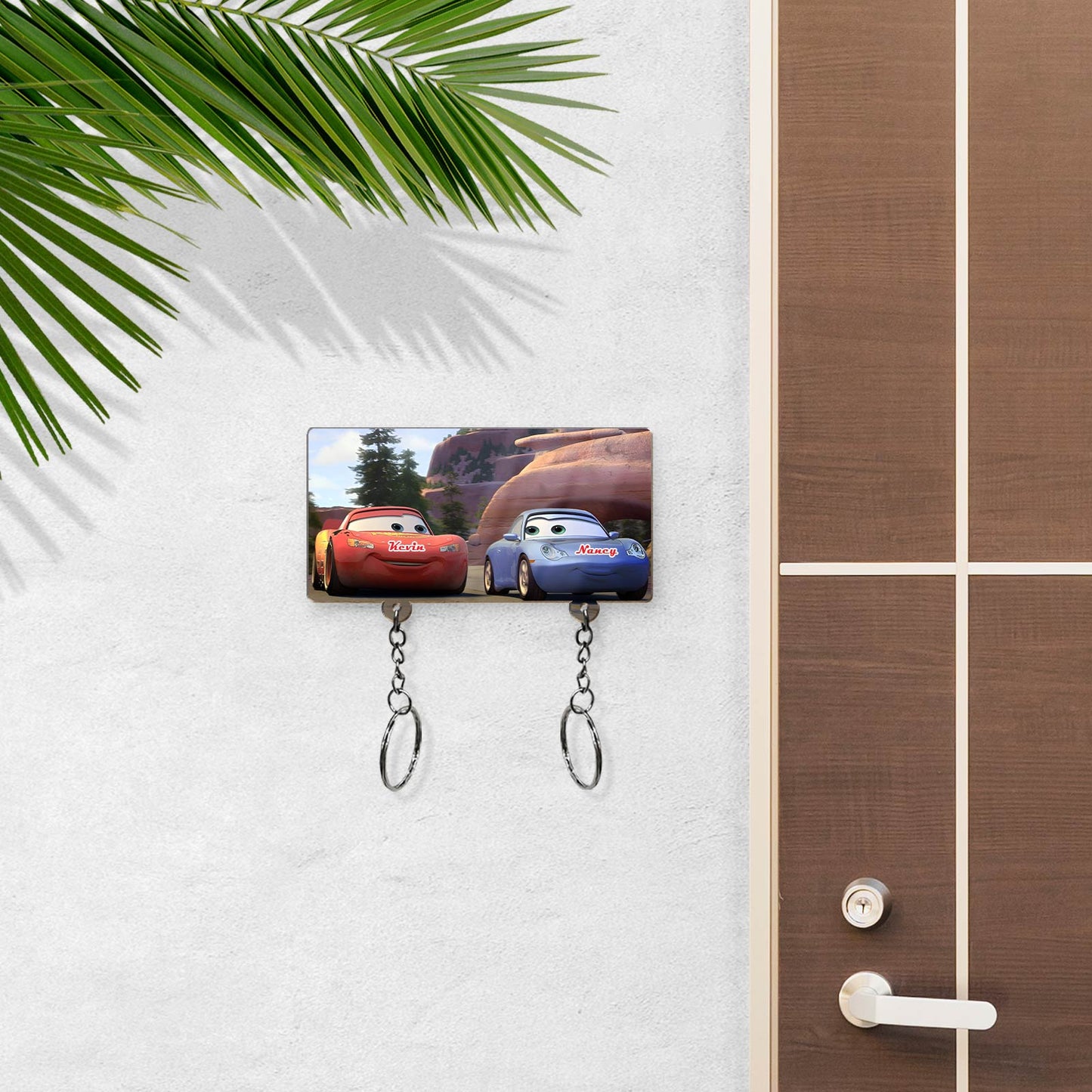 Personalized couple key holder with cartoon car design mounted on wall near wooden door