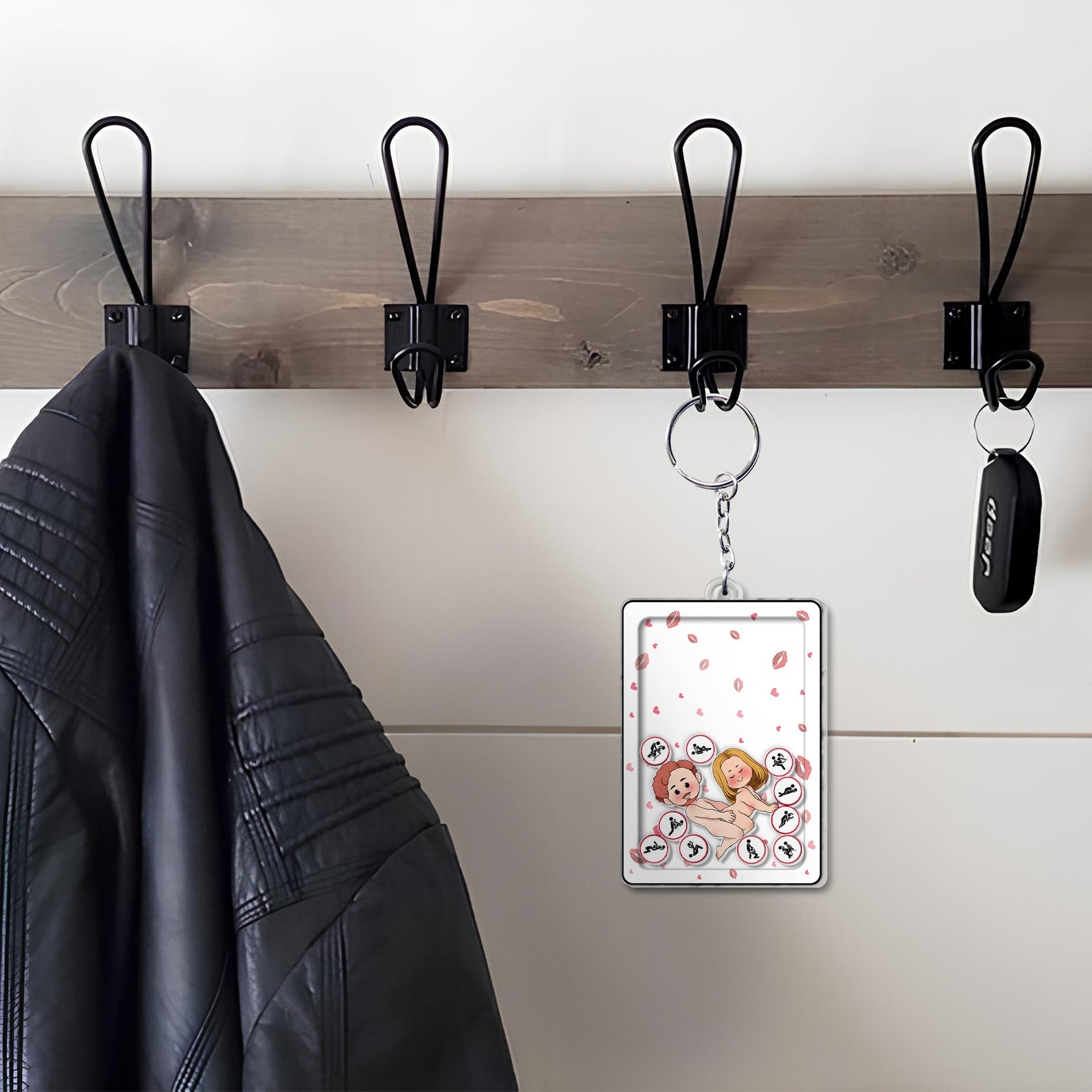 Personalized couple keychain with custom photo hanging on black metal hook beside black leather jacket