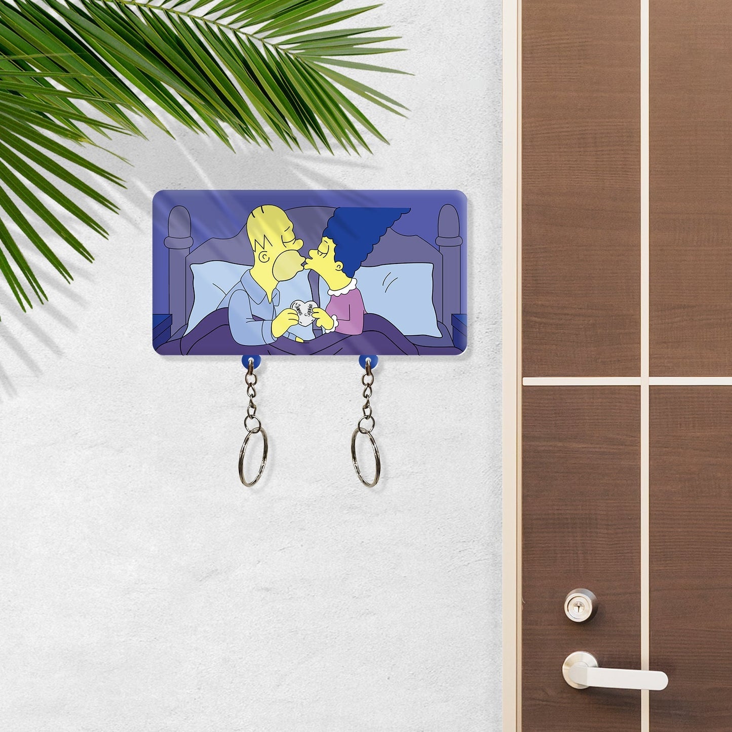Personalized couple keychain holder featuring cartoon couple kissing on bed with two key rings