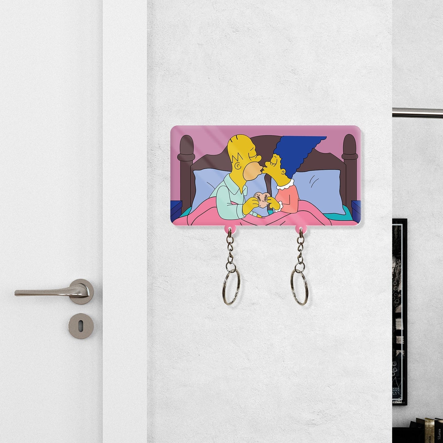 Personalized couple keychain holder featuring a cartoon couple kissing in bed with two keychains hanging
