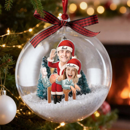 Personalized couple snow globe ornament featuring cheerful figures in festive attire and holiday decor