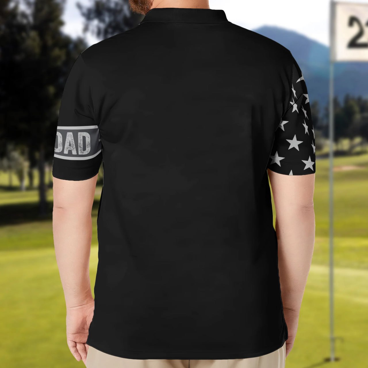 Back view of personalized dad polo shirt in black with star pattern on sleeve and dad text on arm