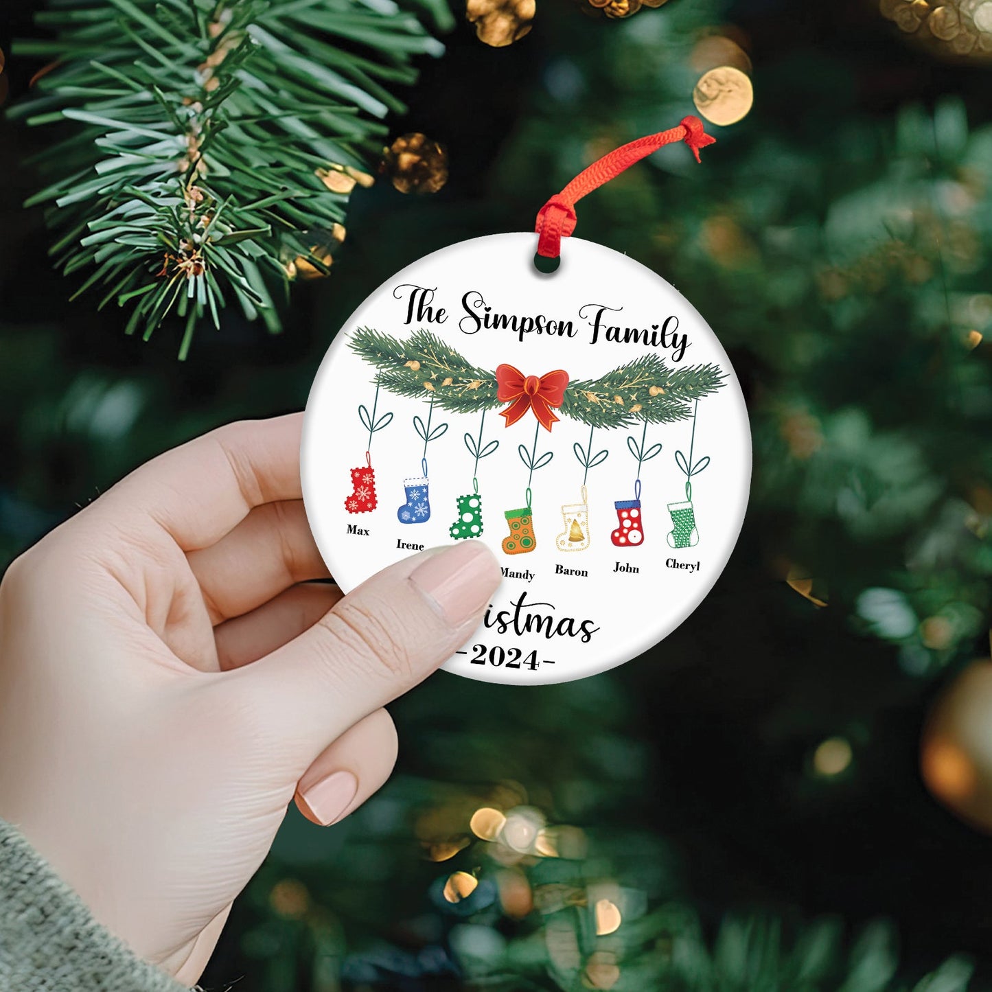 Personalized family Christmas ornament with names and colorful stockings hanging from pine branches