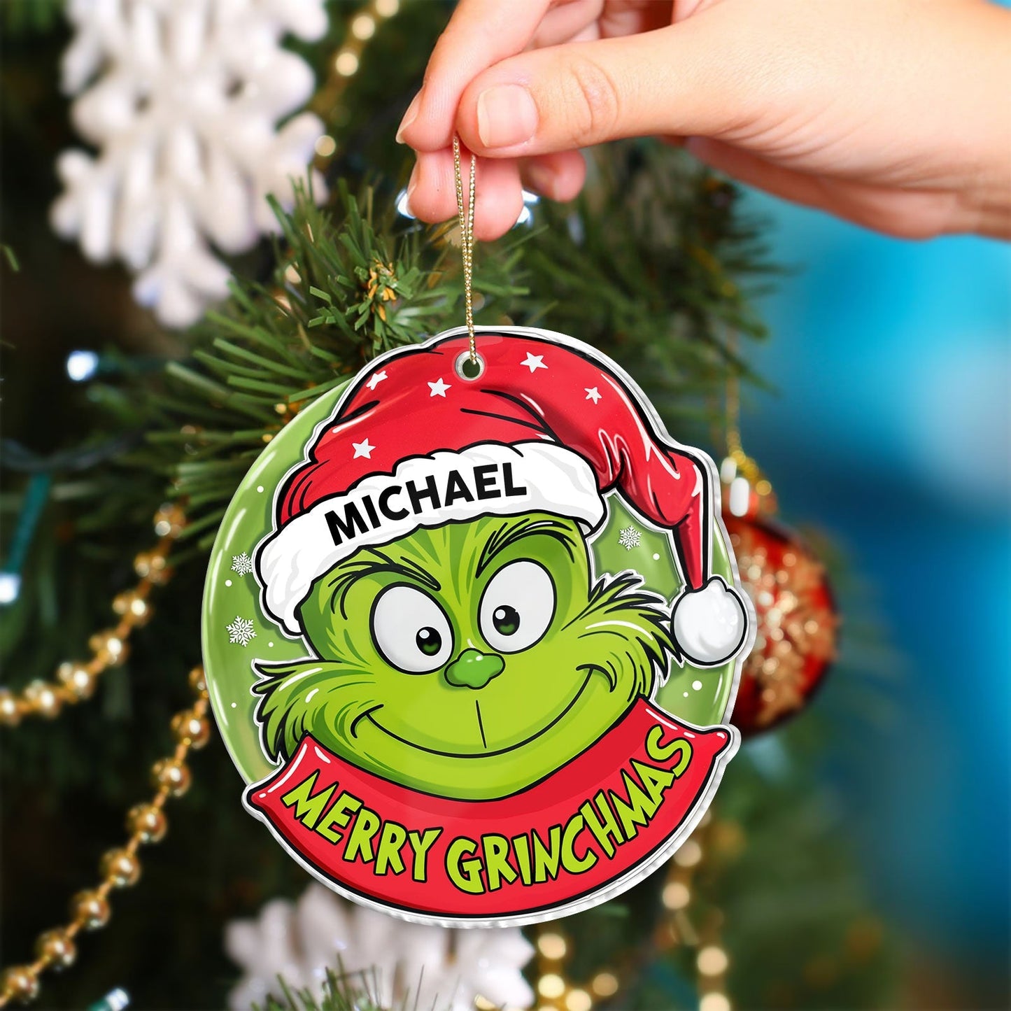 Personalized Grinch Christmas ornament with red Santa hat and name Michael hanging on Christmas tree