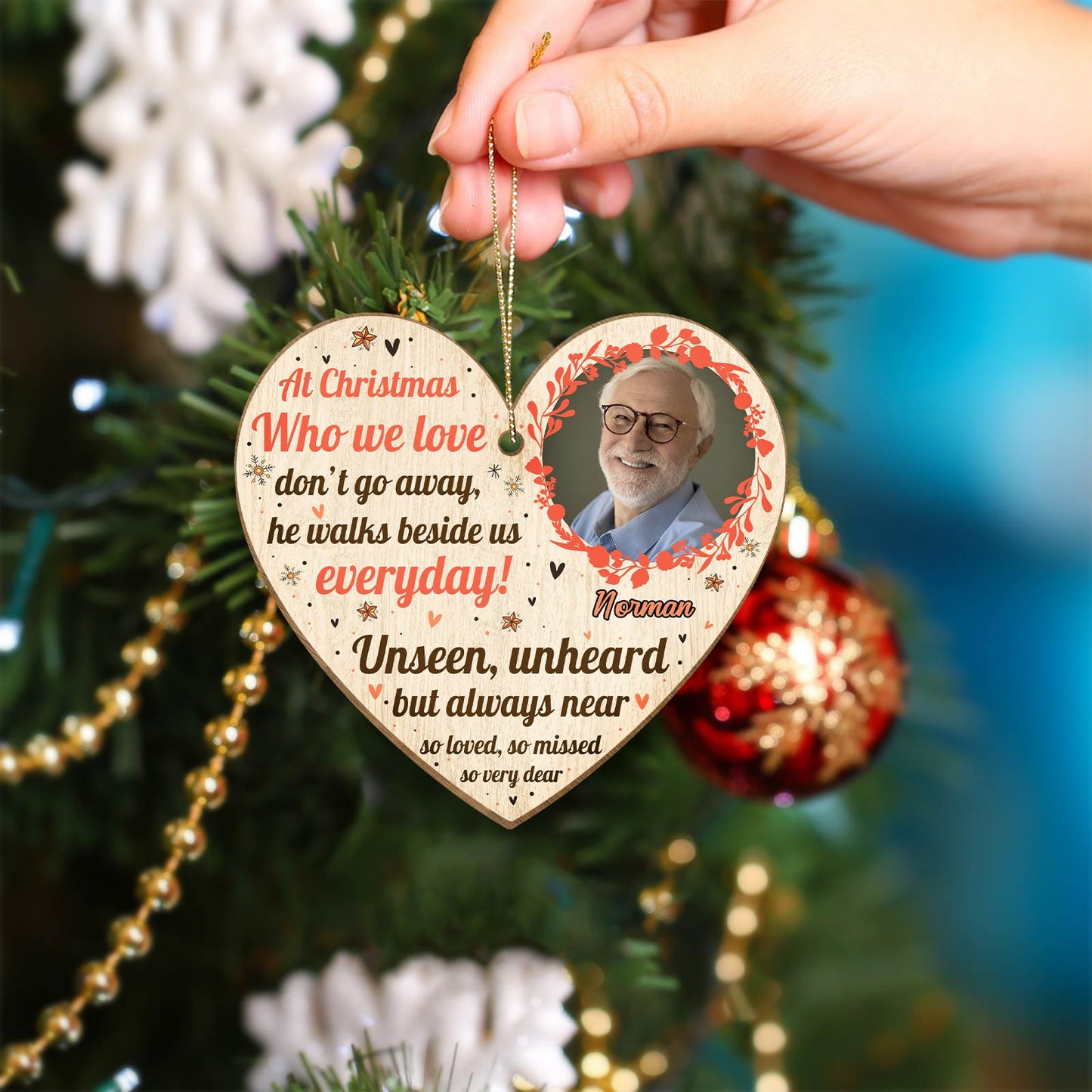 Personalized memorial Christmas ornament heart shaped with photo and sentimental message hanging on tree