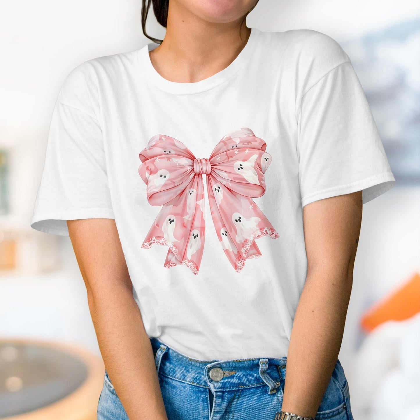White t-shirt featuring a large pink bow with ghost patterns designed as a personalized pink Halloween shirt