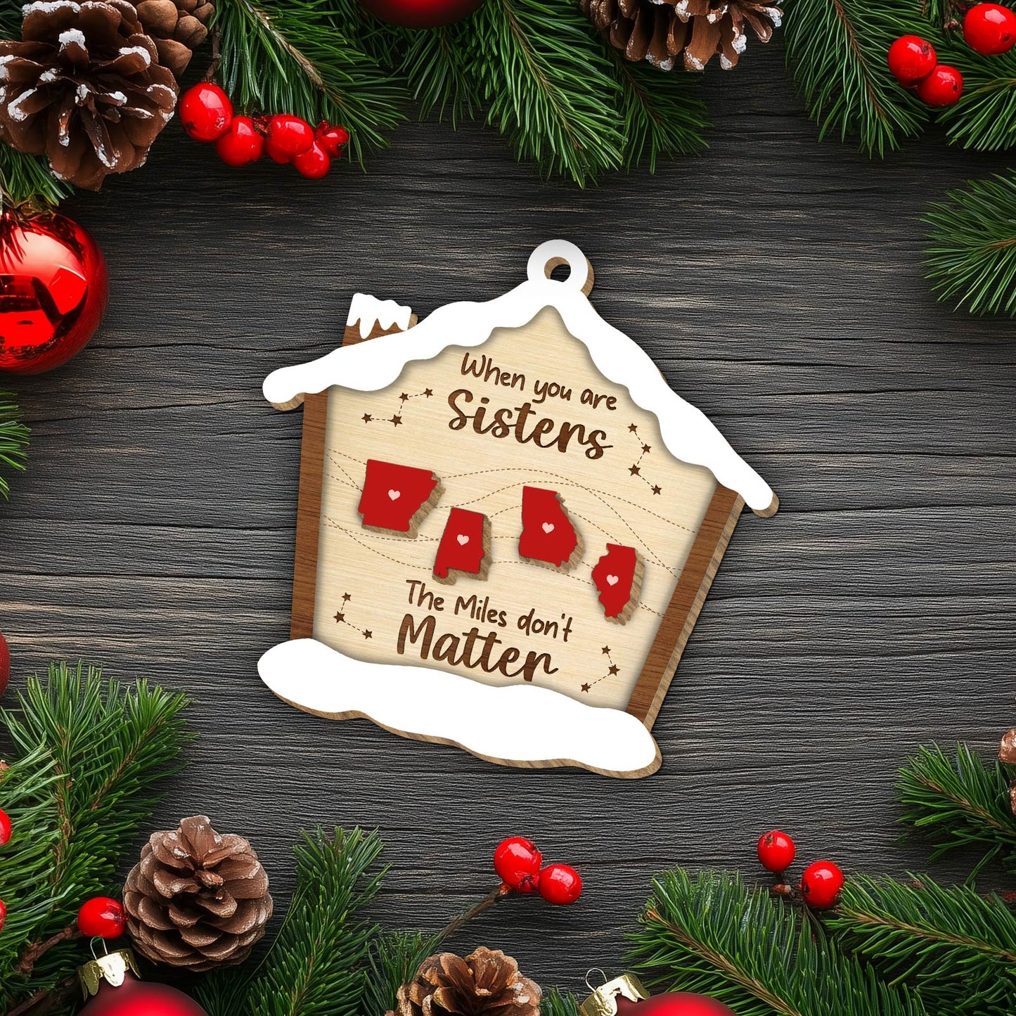 Personalized Christmas ornament with sisters theme featuring state shapes and snow-covered house design