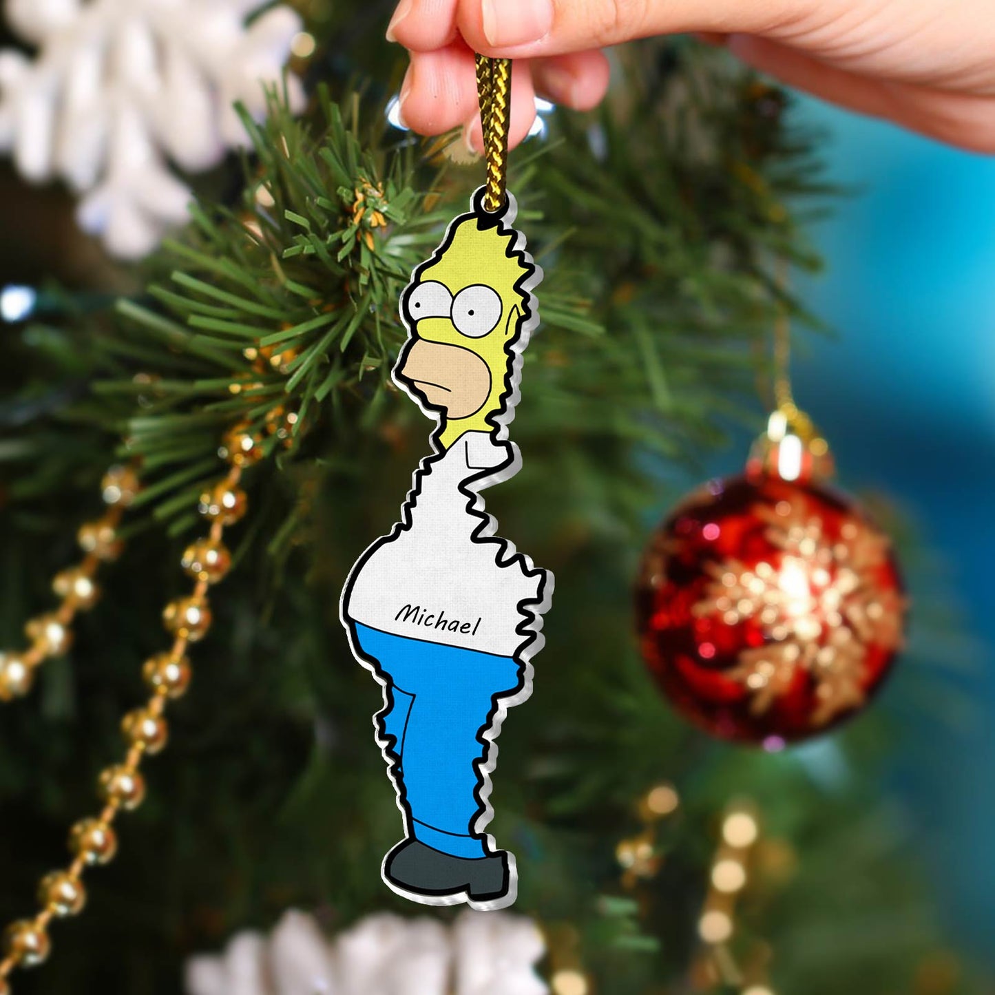 Personalized Christmas acrylic ornament featuring a cartoon character with the name Michael hanging on a Christmas tree