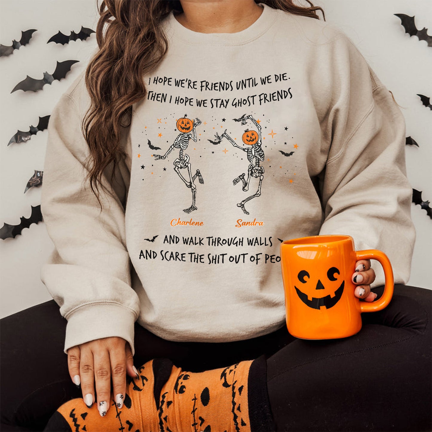 Woman wearing a cream custom best friend Halloween sweatshirt with dancing skeleton pumpkins names and jack o lantern mug