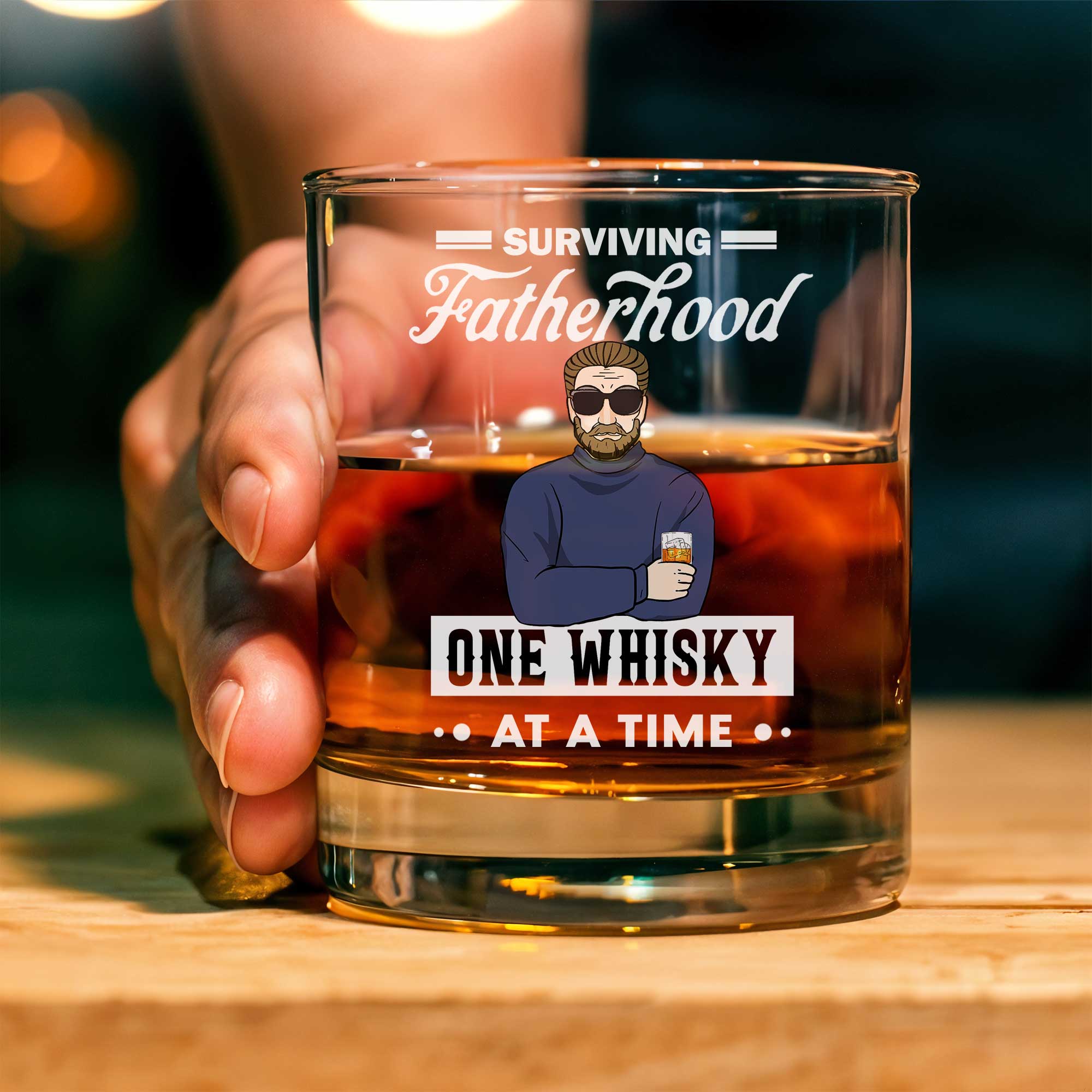 Personalized Whiskey Glass showing held rocks glass with whiskey and fatherhood design One Whisky At A Time