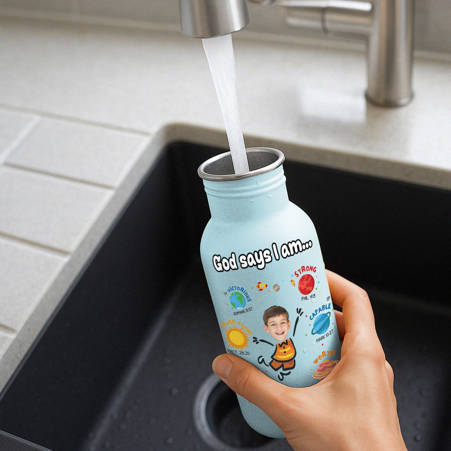 365Gifty blue water bottle for kids with motivational design being filled with water at kitchen sink