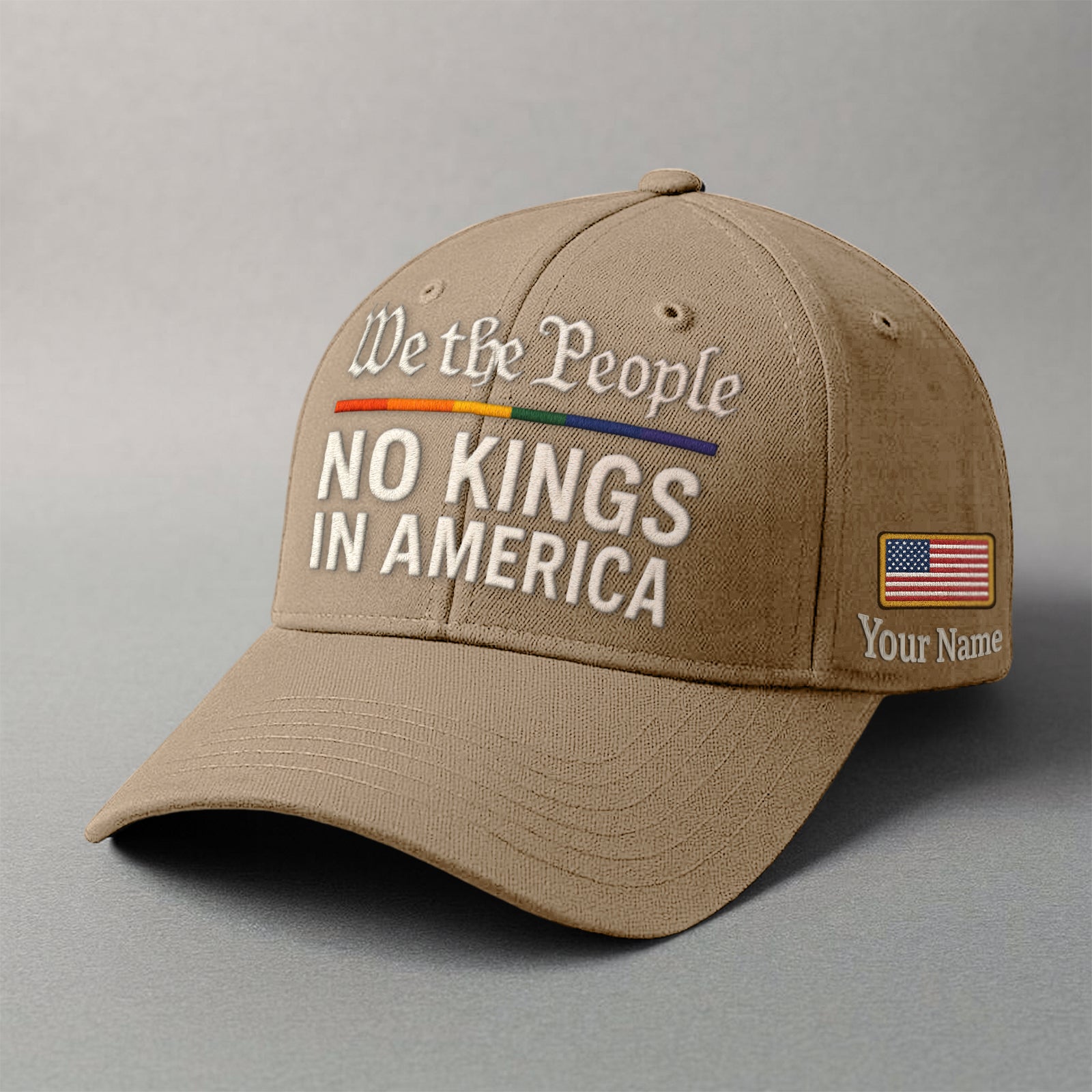 Tan baseball cap featuring 'We the People' embroidered design with a custom name and an American flag patch