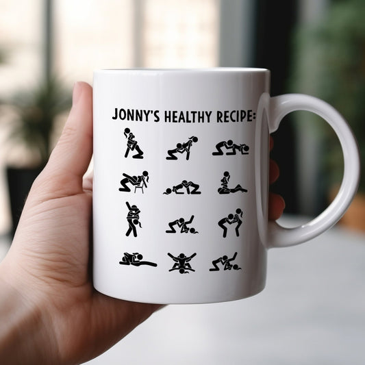 White ceramic funny custom relationship mug showing Jonnys Healthy Recipe text and black playful couple silhouette icons