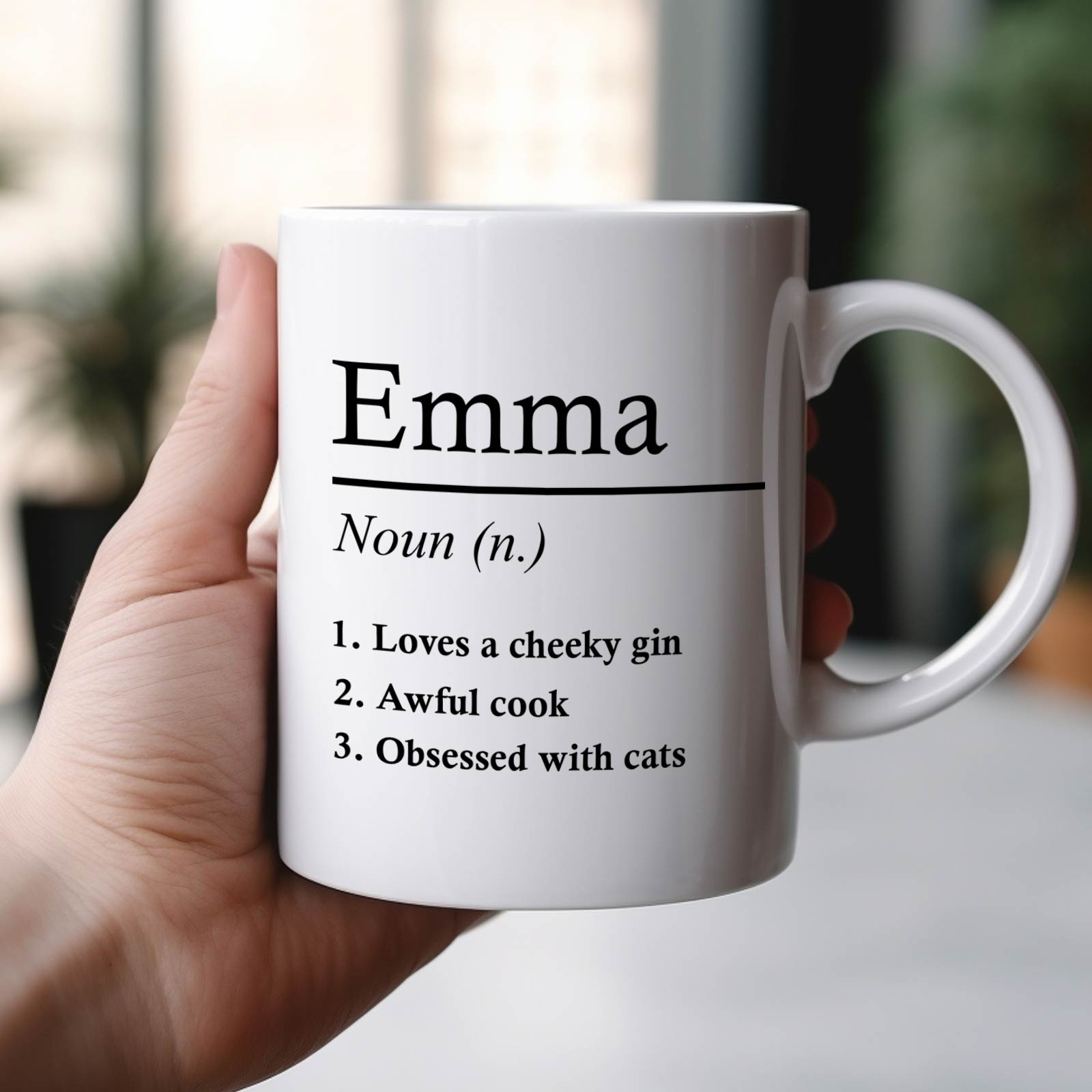 White ceramic personalized Emma mug with printed humorous definition list held in hand funny definition mug for family