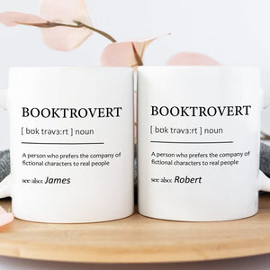Pair of white personalized booktrovert mug displaying definition print and names James and Robert on wooden tray