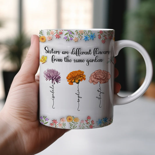 365Gifty sisters are different flowers mug held in hand white ceramic with three labeled illustrated flowers and floral border