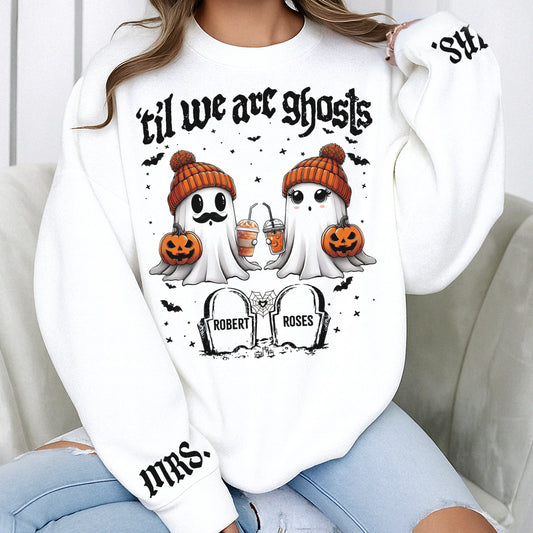 White personalized Halloween couple shirt showing two ghosts in orange beanies holding pumpkins and tombstones with names
