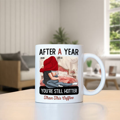 White coffee mug with after a year still hotter than coffee mug design featuring a couple hugging on bed