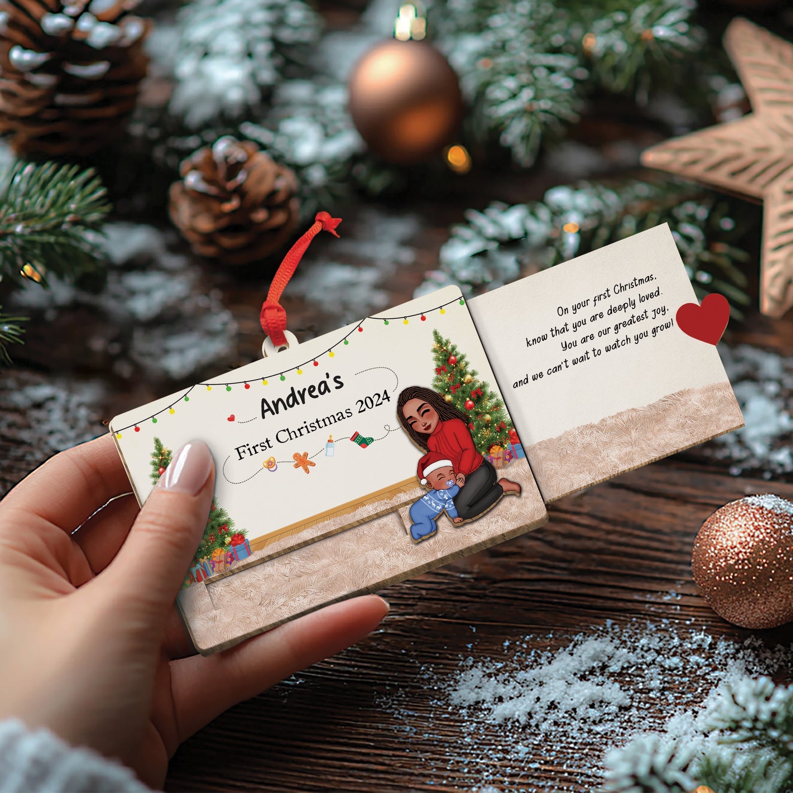 Hand holding custom wooden Christmas slider card with holiday design and personalized text for Andrea's first Christmas 2024