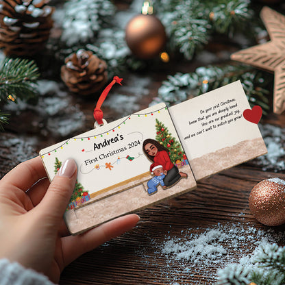 Hand holding custom wooden Christmas slider card with holiday design and personalized text for Andrea's first Christmas 2024