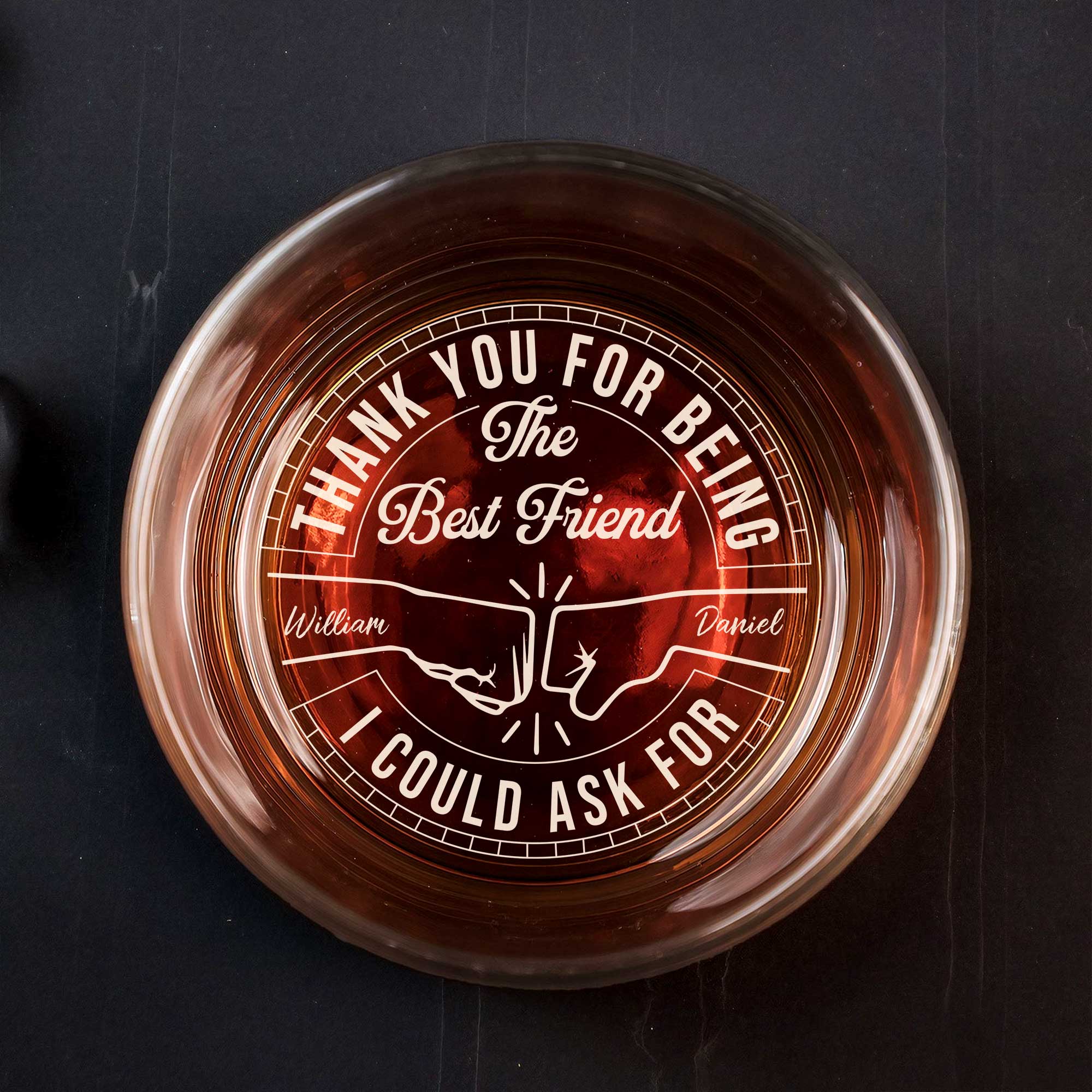Personalized Whiskey Glass top view with engraved thank you best friend message names William and Daniel over amber whiskey