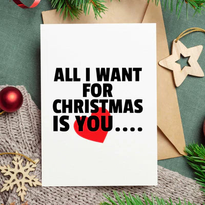 Funny Christmas card for couples with message All I Want For Christmas Is You and red heart on white card