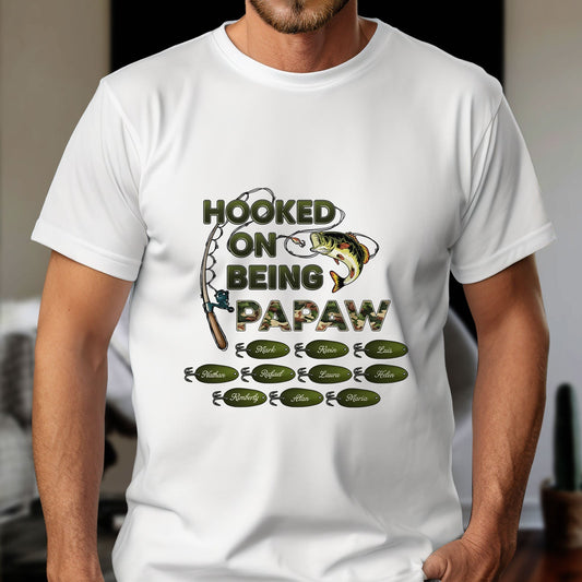 White shirt with fishing design and hooked on being grandpa shirt text featuring fish and fishing rod