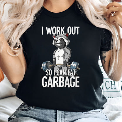Humorous workout apparel black t-shirt featuring muscular raccoon lifting weights with text I work out so I can eat garbage