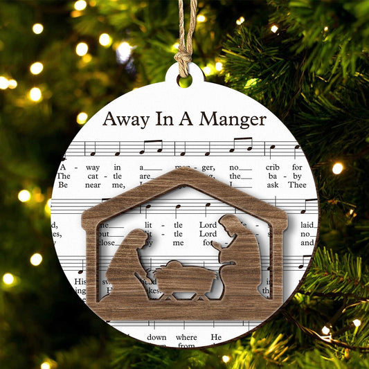 Music sheet nativity ornament with Away In A Manger song and wooden nativity scene silhouette hanging on Christmas tree