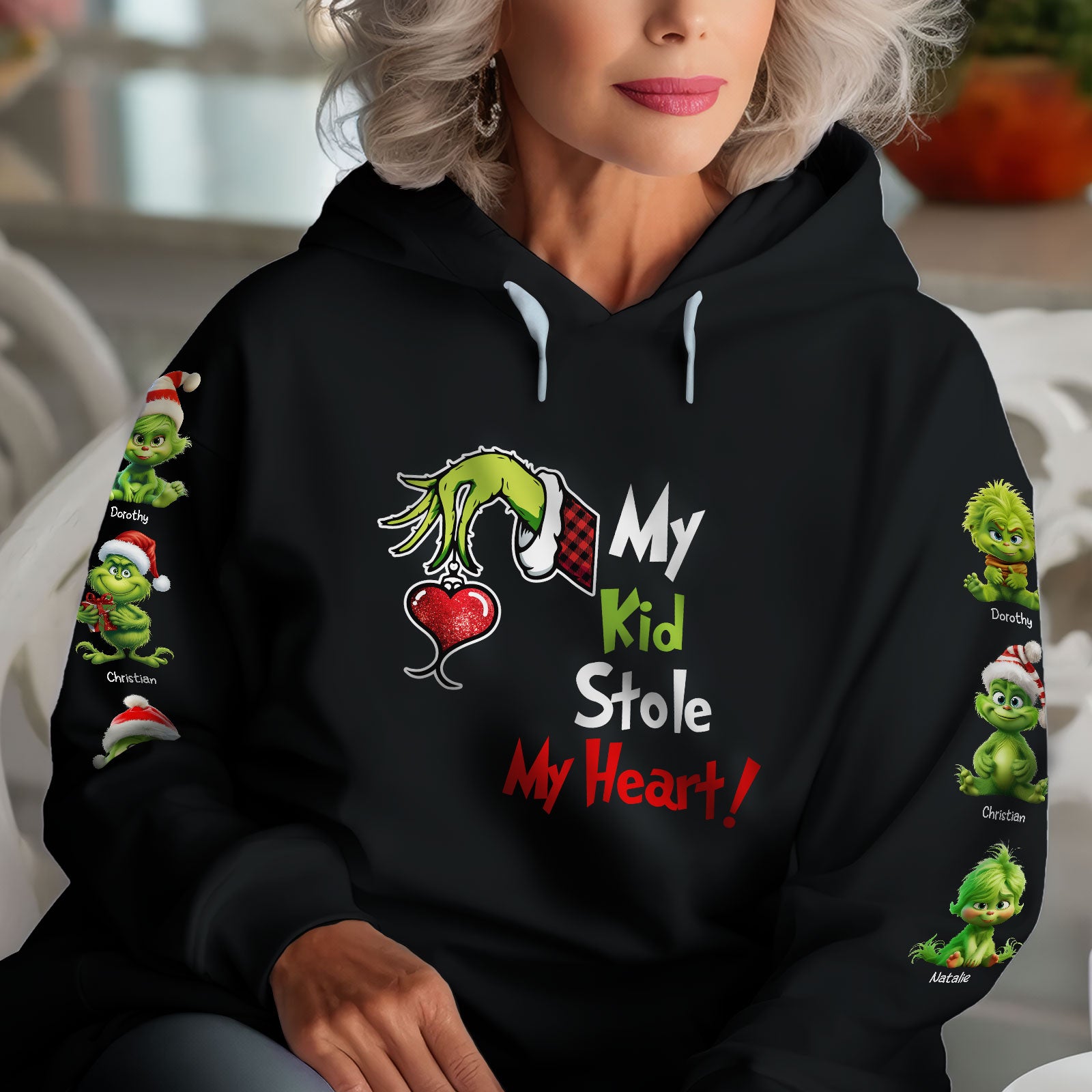 Black hoodie with Grinch hand holding heart and text my kid stole my heart shirt design