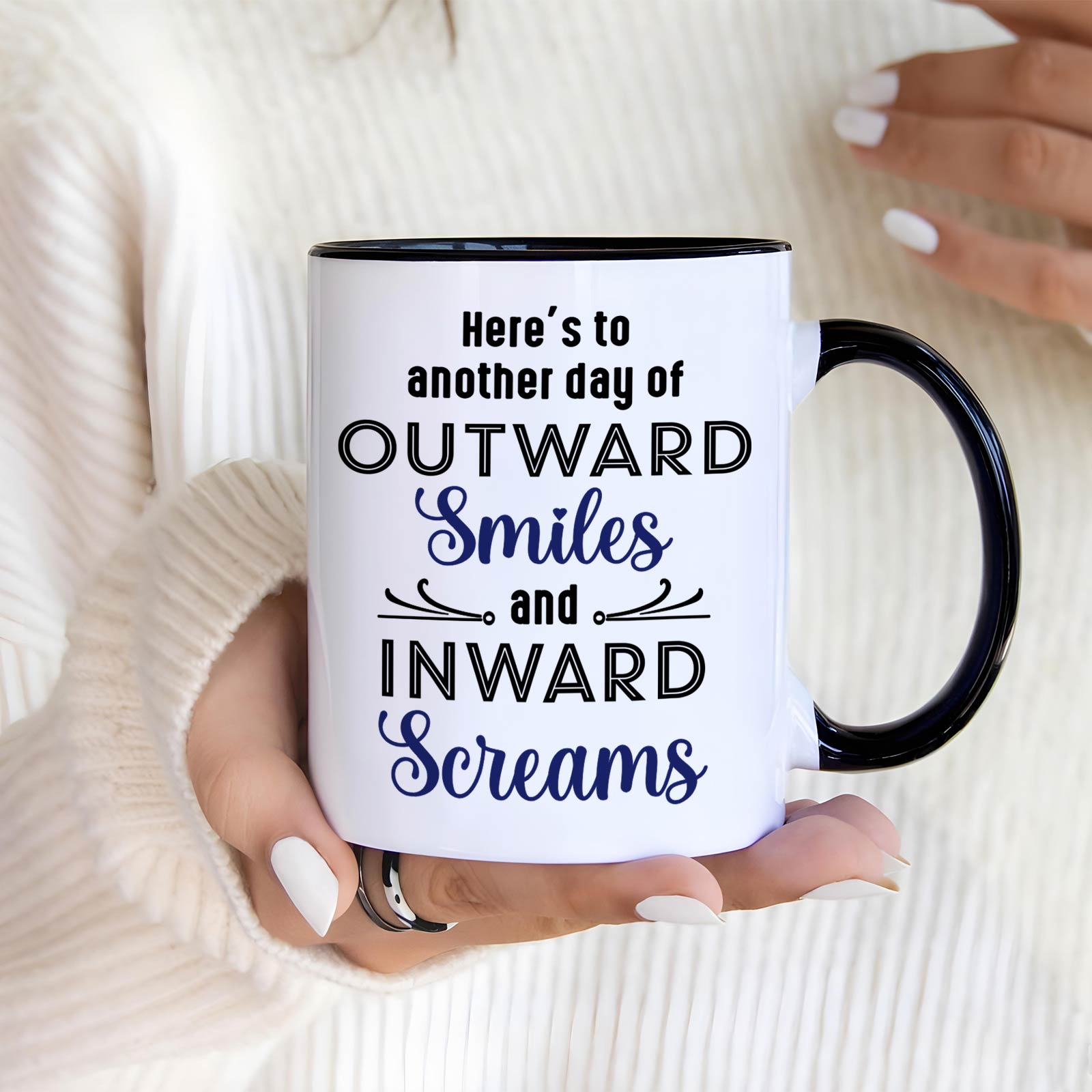 Personalized coworker mug with black handle and printed quote Outward Smiles and Inward Screams held by person in white sweater